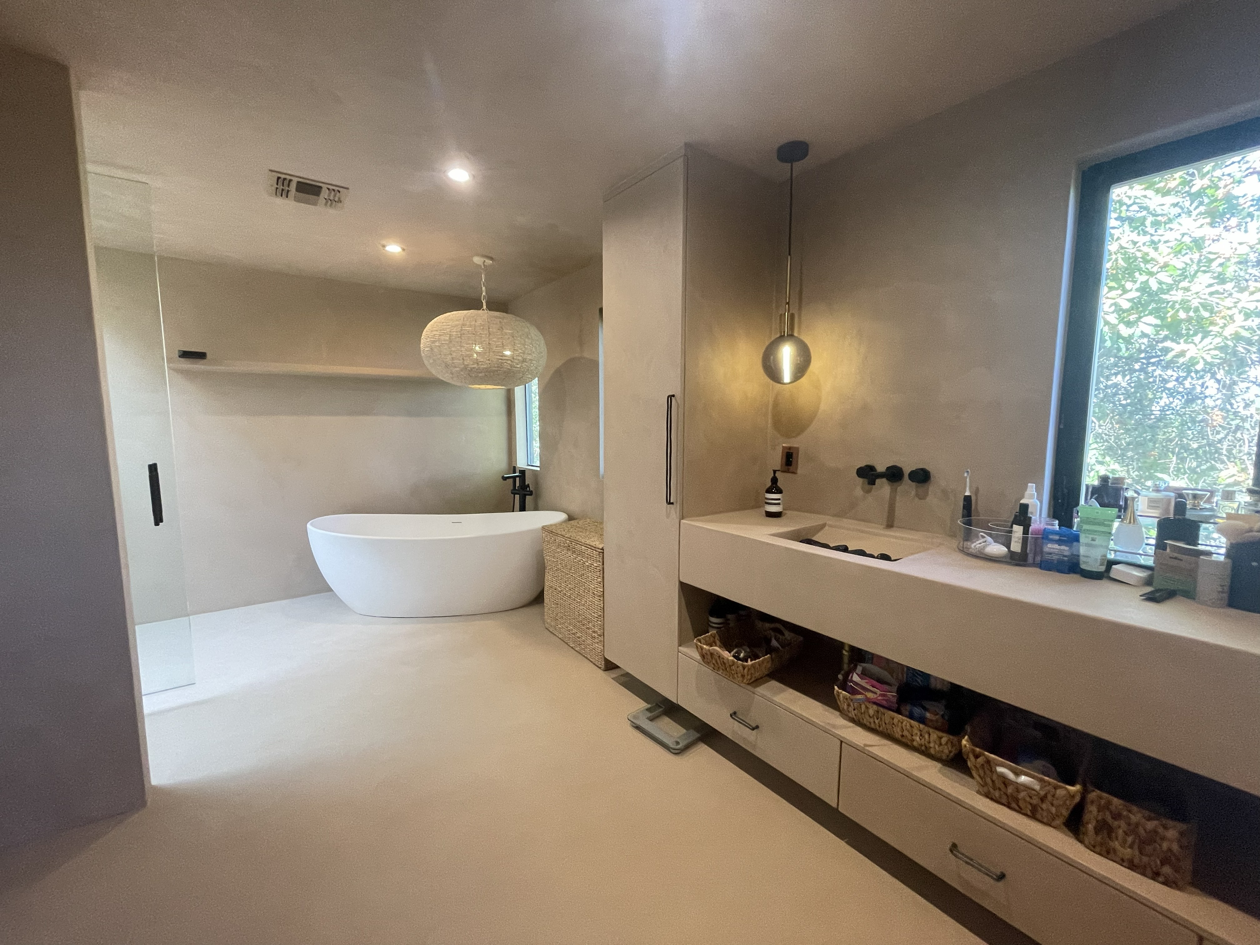 Luxury master bathroom with microcement vanity and freestanding tub - Pacific Palisades