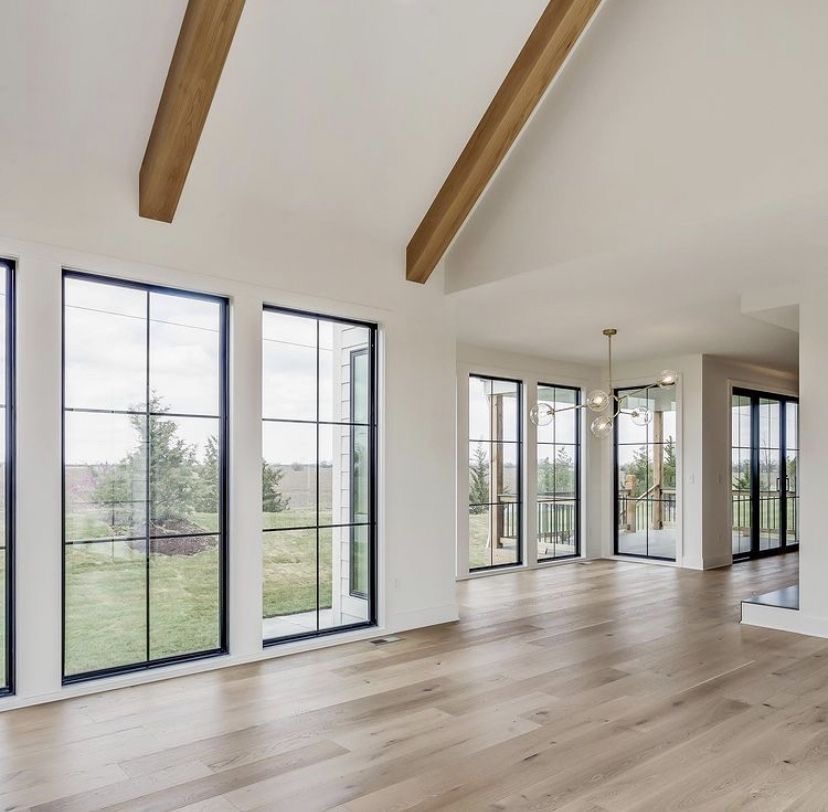 Room addition with floor to ceiling black frame windows and wood beams - Los Angeles